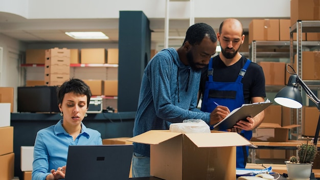 Compañia ballenita 98 SL - Servicios - entrepreneurs team preparing shipment order with products from warehouse racks working delivery logistics with laptop diverse people planning business development supply chain